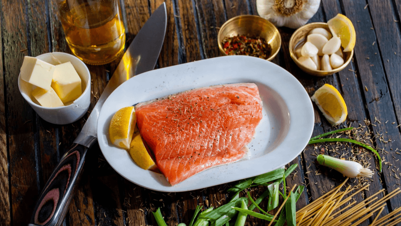 Plate of salmon surrounded by butter, garlic, and spices