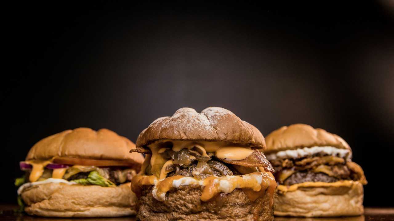 Three large cheeseburgers with relish.