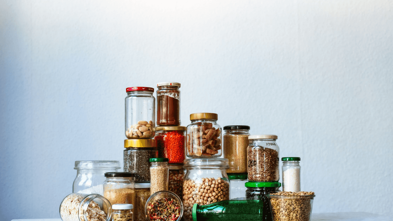 Stacked glass jars filled with dehydrated meat and various nuts and seeds.