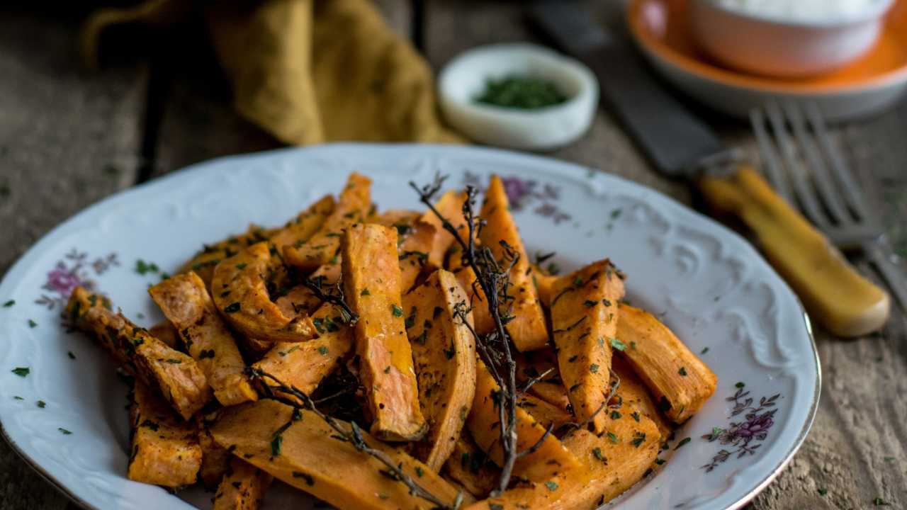 A plate of roasted and seasoned sweet potato sticks.