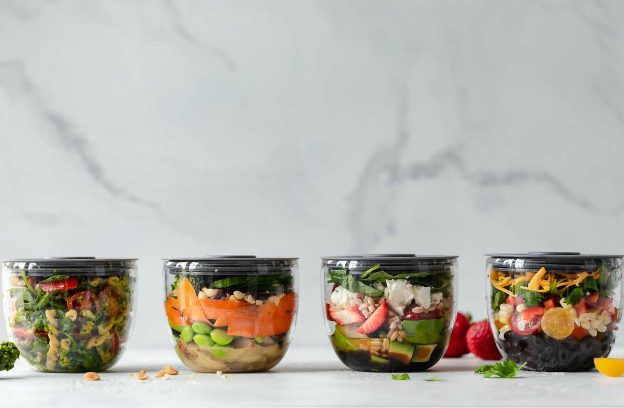 Lined up containers filled with colorful prepared meals